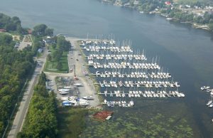 Aerial view of Collins Bay Marina in Kingston, Ontario with sailboats docked along Lake Ontario