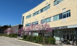 Exterior view of Kingston Secondary School with spring blossoms in front