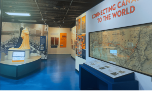 Interior view of the Great Lakes Museum, featuring mannequins in period clothing, a large railway map, and exhibits highlighting Canada’s global connections.