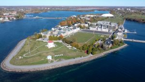 Aerial view of the Royal Military College of Canada campus on Point Frederick in Kingston, Ontario, showing historic stone buildings, parade square, and waterfront location
