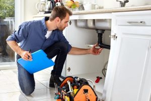 Home inspector examining the plumbing of a house for buyers