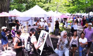 Crowds browsing outdoor booths at the Women’s Art Festival in Kingston’s City Park.