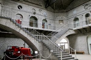 Interior view of Kingston Penitentiary’s central dome, featuring the radiating cellblock corridors and historic fire cart on display