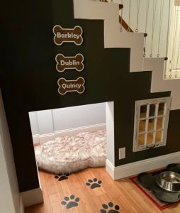 Custom under-the-stairs dog nook with cozy bed and feeding station
