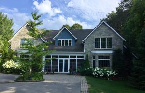 Rural Eastern Ontario home with stone exterior, landscaped gardens, and circular driveway — strong curb appeal example