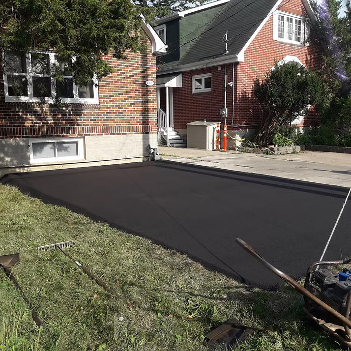 Freshly sealed asphalt driveway at a residential property; one of the many maintenance costs a homeowner has to budget for