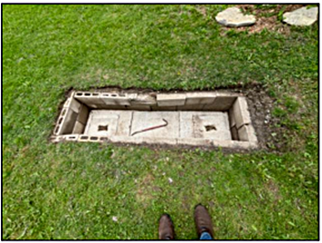 Septic system access lid in a residential yard used for inspection and maintenance.
