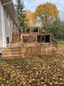 Custom wood deck in Kingston surrounded by autumn leaves, showing seasonal renovation timing