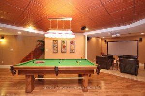 Over-renovated basement with copper ceiling, theatre seating, and billiards table in Kingston home