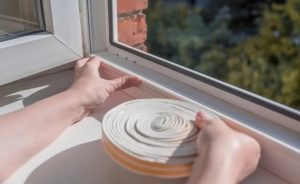 homeowner applying weather stripping during winter preparation Kingston Ontario Bill Stevenson Century 21 Lanthorn Real Estate