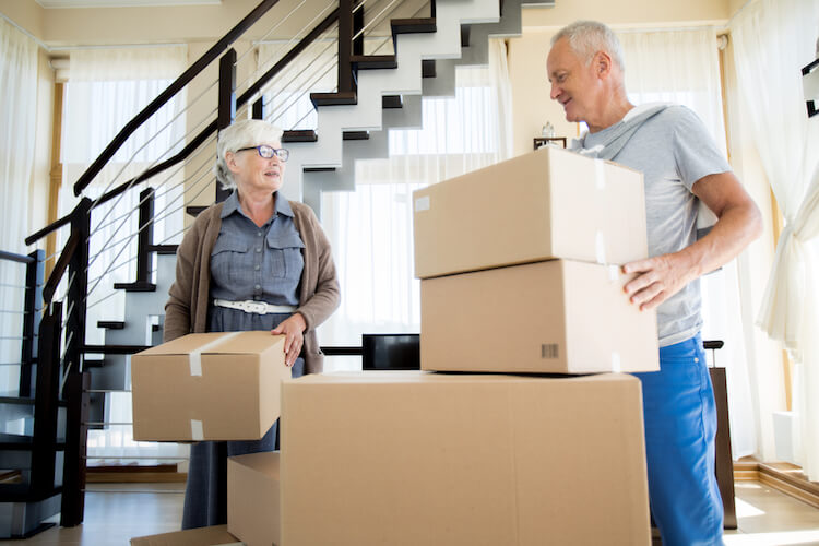 Senior couple packing boxes while downsizing their home in Kingston, Ontario