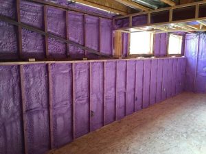 Basement walls with purple spray foam insulation in a Kingston Area home