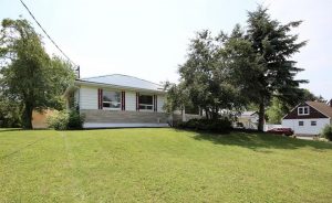 Single-storey family home in Kingston Mills, owned by one family for nearly 60 years, surrounded by mature trees and bright summer light. Bill Stevenson, REALTOR®, Century 21 Lanthorn Real Estate Ltd., Brokerage.