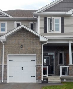 Two-storey Kingston townhome with single-car garage and small front porch.