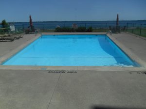 Outdoor pool at a Kingston condominium with a view of Lake Ontario