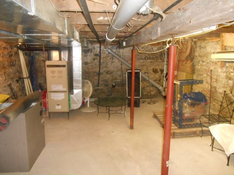Basement of an older Kingston home showing exposed stone walls, support posts and mechanicals, illustrating potential home inspection deal breakers. Bill Stevenson, REALTOR®, Century 21 Lanthorn Real Estate Ltd., Brokerage.