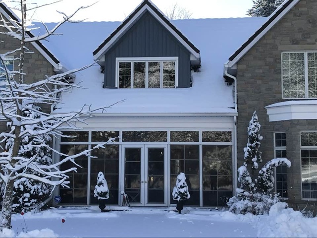 Residential home in winter showing large triple glazed windows and features associated with eco-friendly construction