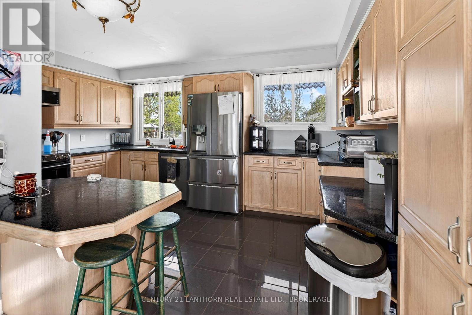 Bright family kitchen with breakfast bar and stainless steel appliances in Amherstview side-split home