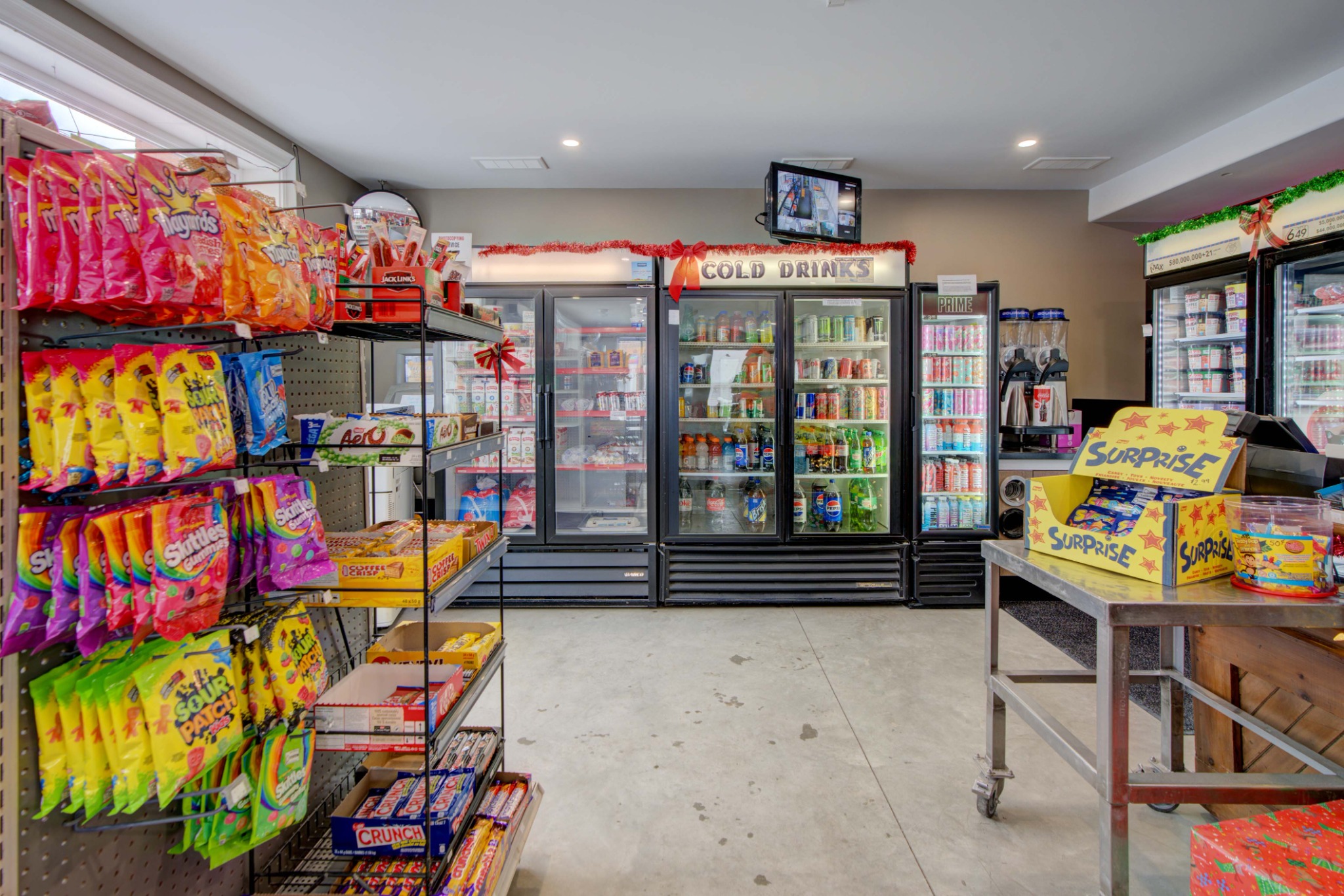 Interior retail space at Chit Chat Convenience and Pizzeria in Lyn Ontario featuring coolers, shelving, and retail display area