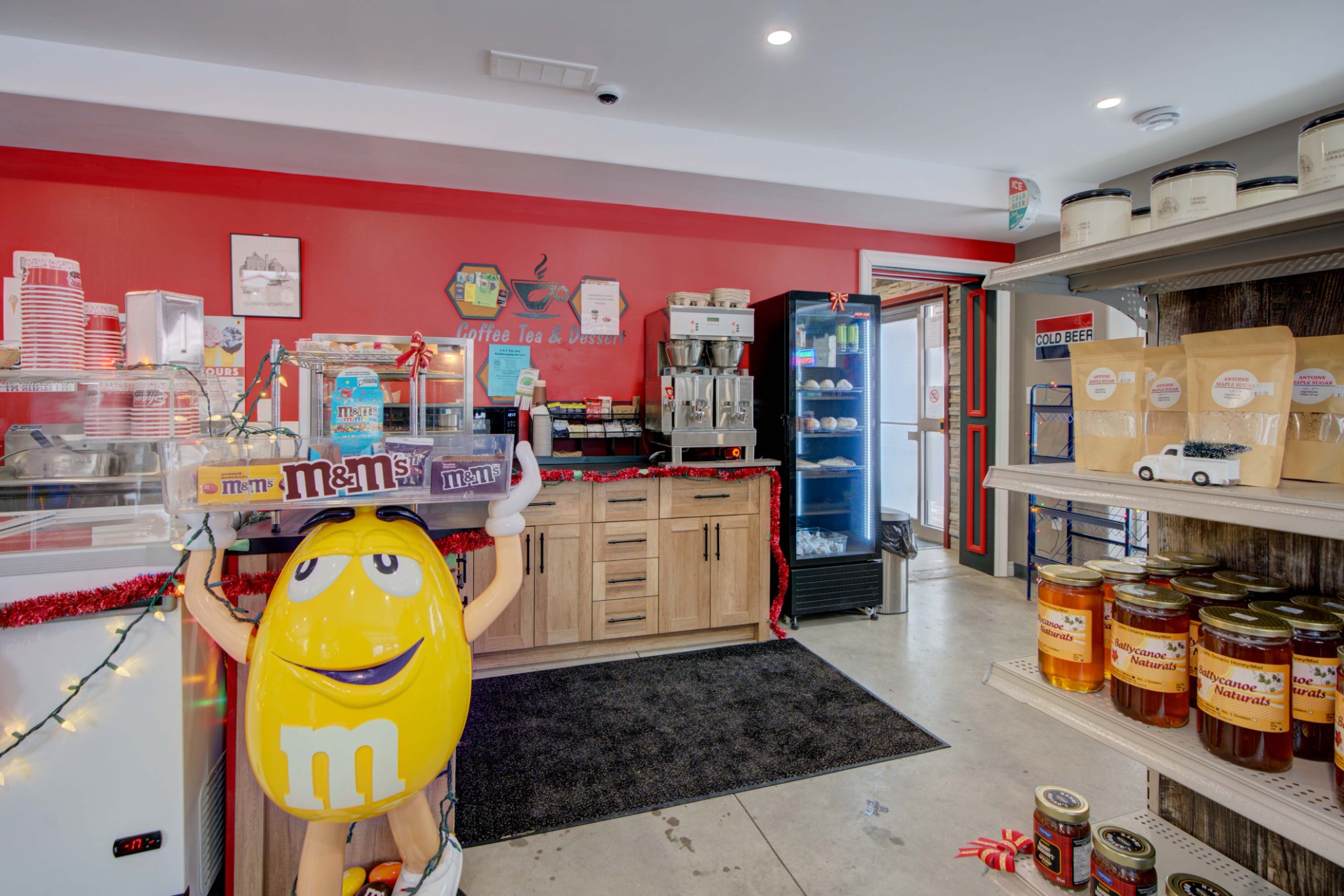 Coffee station, desserts, candy, and specialty retail products displayed in a modern convenience and takeout setting.