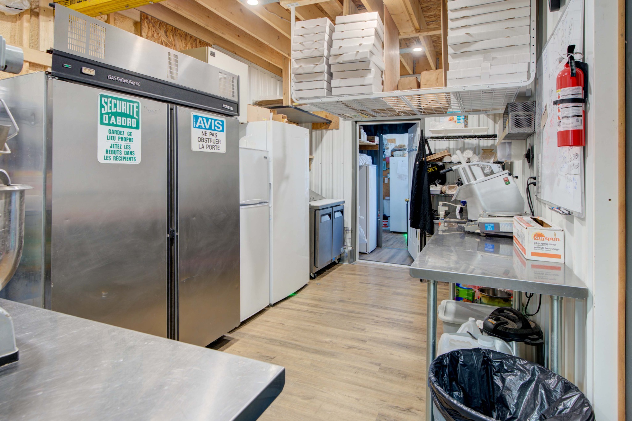 Commercial kitchen preparation area in Lyn Ontario featuring stainless steel workspace, refrigeration, and food preparation equipment