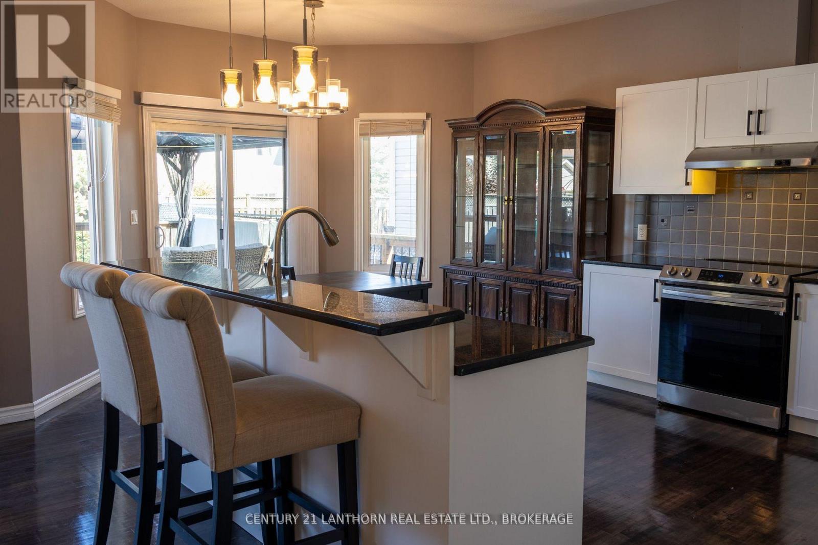 Open-concept kitchen and dining area with granite counters and backyard access in Kingston family home