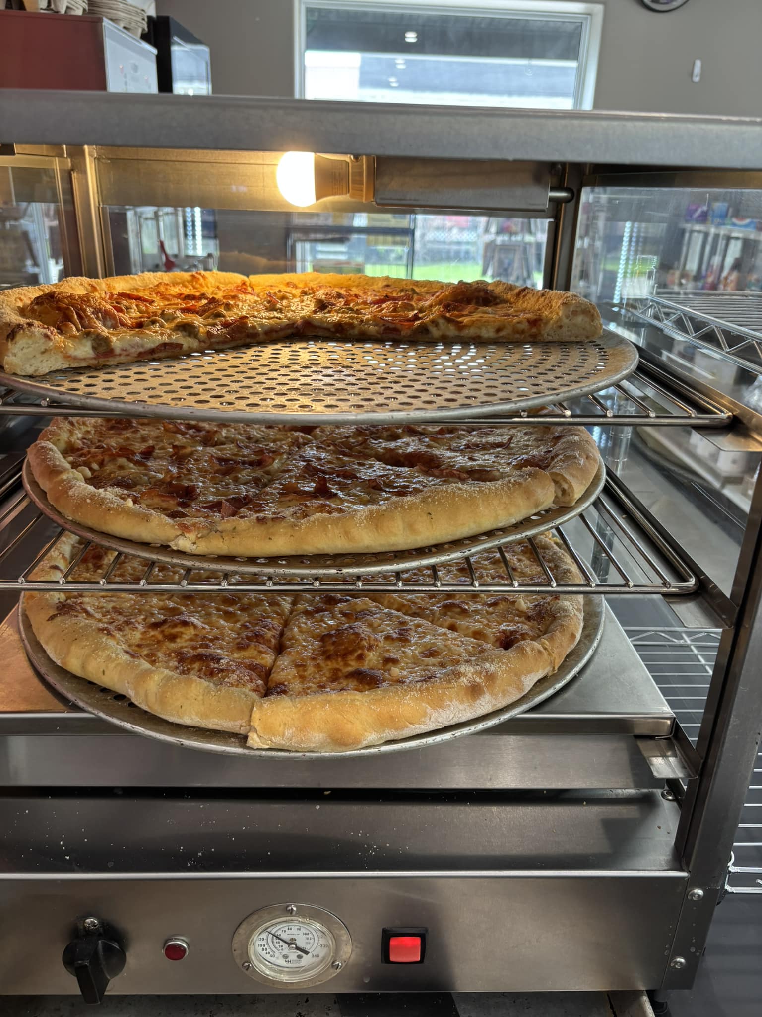Fresh pizza displayed in commercial warmer at Chit Chat Convenience and Pizzeria in Lyn Ontario.