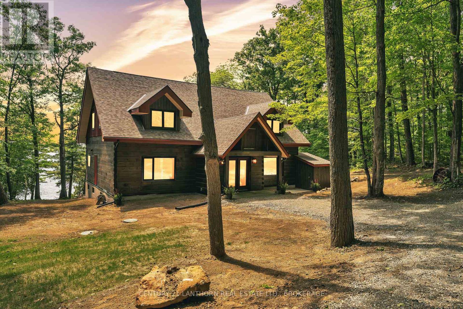 Luxury waterfront log home on Sharbot Lake in Frontenac County with private wooded setting and renovated exterior