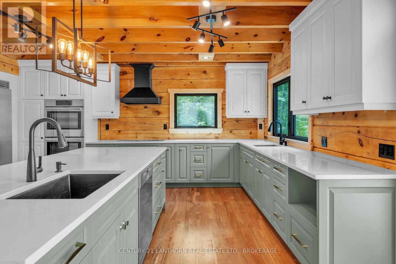 Modern renovated kitchen with quartz counters and exposed wood interior in Sharbot Lake waterfront home