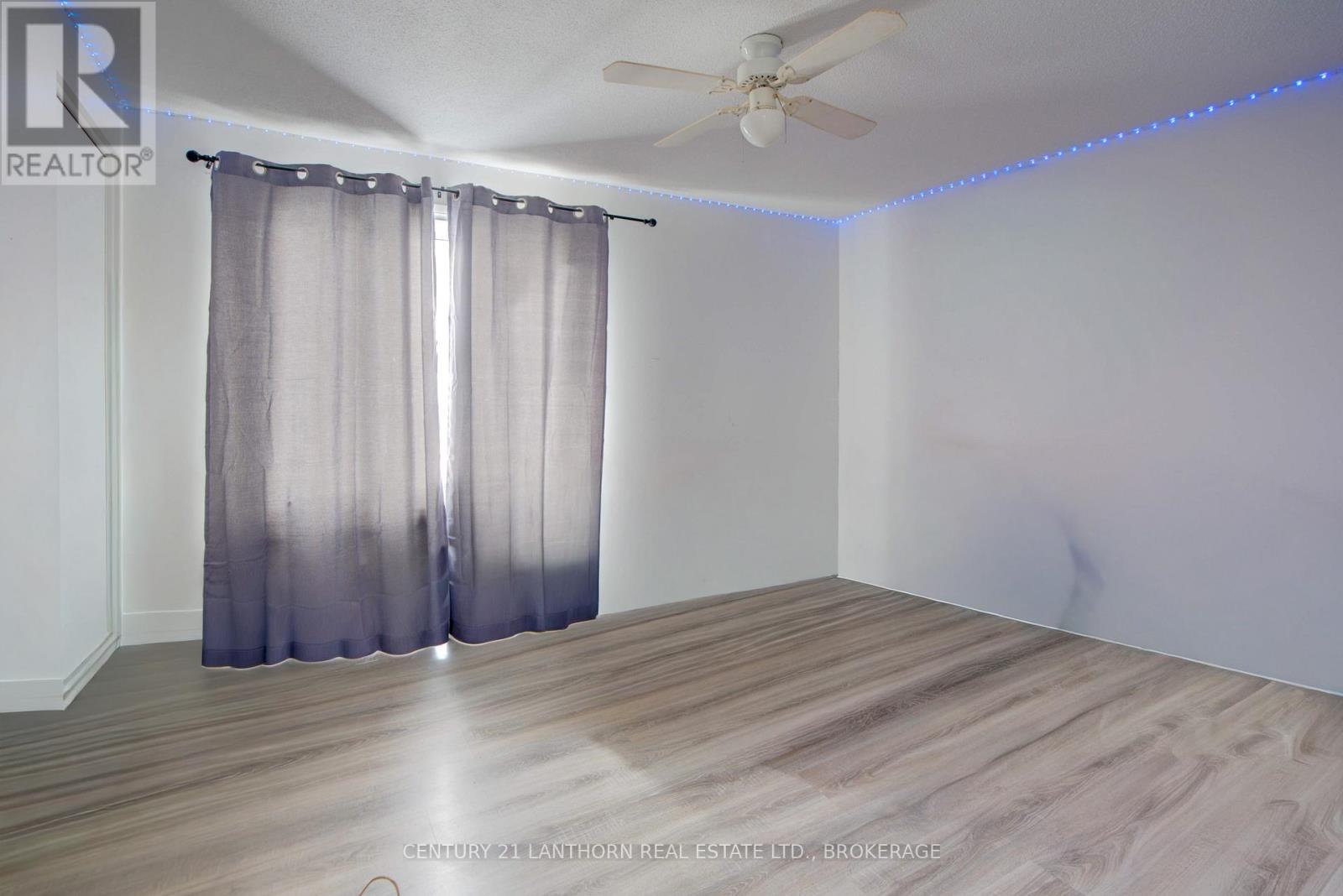 a four bedroom home, this is the primary featuring updated flooring, large window, ceiling fan, and ample space for bedroom furnishings. Bill Stevenson, REALTOR®, Century 21 Lanthorn Real Estate Ltd., Brokerage.