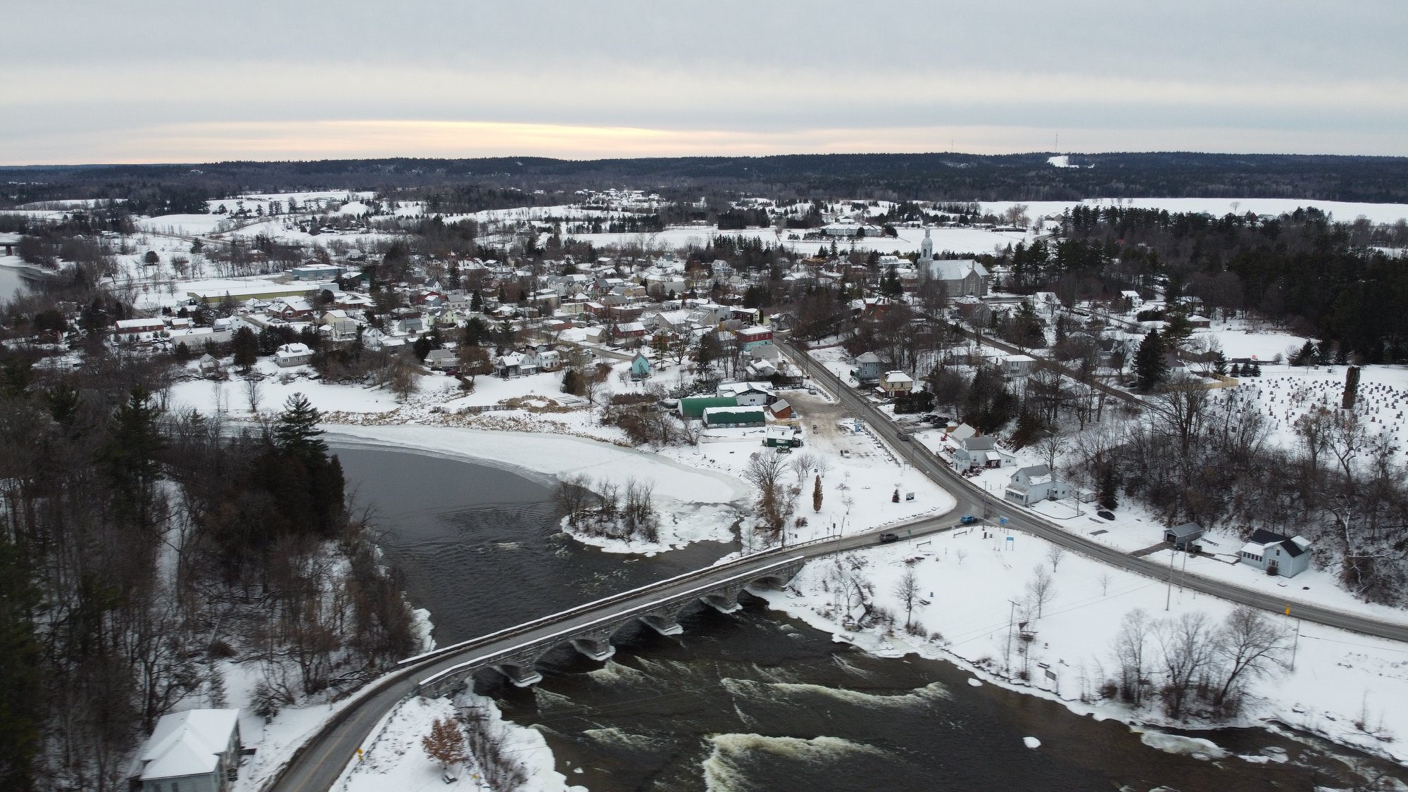 Moving to a small town near Kingston during winter, aerial view of a rural Ontario village showing snow-covered homes, roads, and community buildings. Bill Stevenson, REALTOR®, Century 21 Lanthorn Real Estate Ltd., Brokerage.
