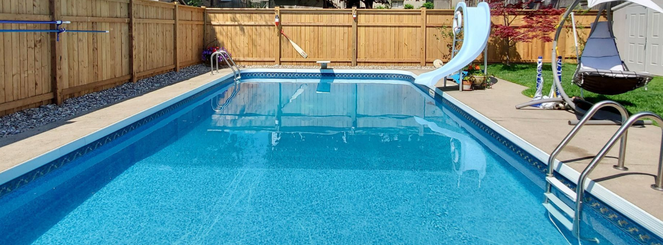 House with a pool showing an in-ground swimming pool, wood fencing, slide, ladders, and surrounding patio